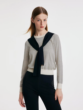 a lady wearing a striped woolen sweater with shawl